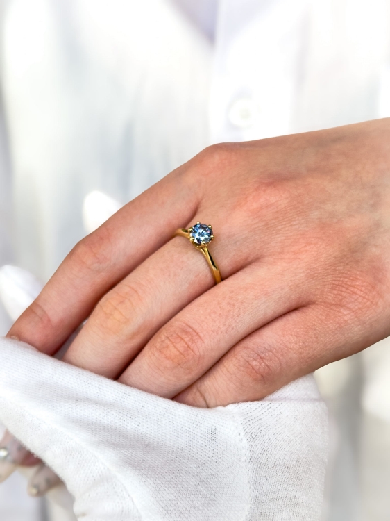 Pierścionek zaręczynowy z żółtego złota próba 585 z niebieskim moissanitem 0,80 ct – na dłoni – ABGOLD Baczyński