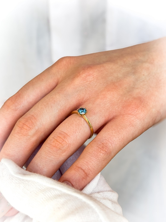 Pierścionek zaręczynowy z żółtego złota próba 585 z niebieskim moissanitem 0,50 ct – na dłoni – ABGOLD Baczyńsk