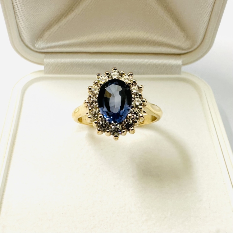 Pierścionek z żółtego złota próba 585 z szafirem i moissanitami – widok frontalny na tkaninie – ABGOLD Baczyński