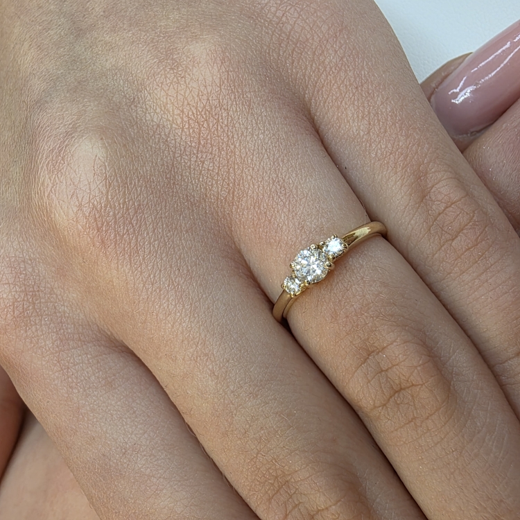 Złoty pierścionek zaręczynowy próba 585 z brylantami – na dłoni z bliska – ABGOLD Baczyński