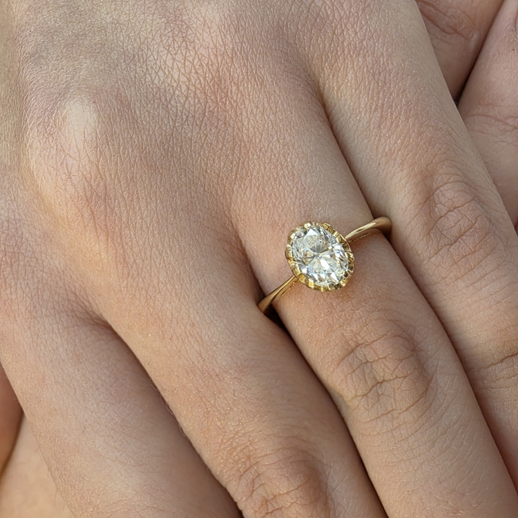 Pierścionek zaręczynowy z żółtego złota próba 585 z owalnym moissanitem – zbliżenie na dłoni – ABGOLD Baczyński